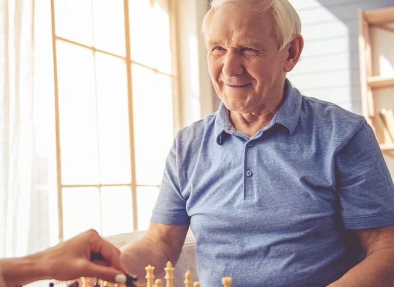 Älterer Mann spielt Schach